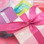 close up of pink and purple square gift boxes tied with ribbon